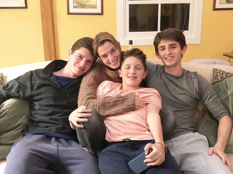 Image of chef Pati Jinich with her three sons sitting in a sofa